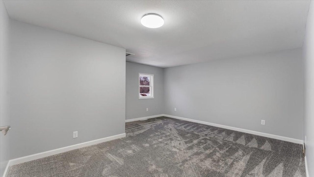 carpeted spare room featuring baseboards