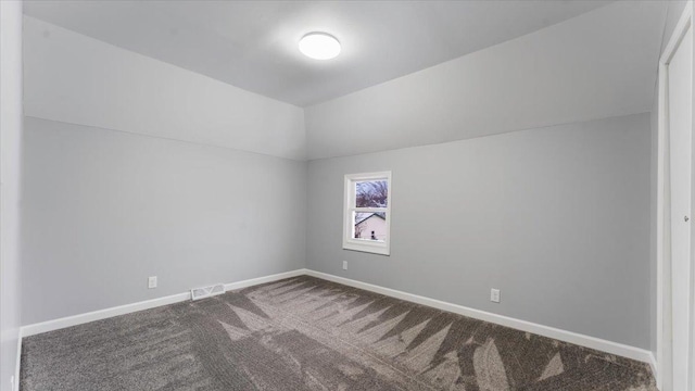 carpeted empty room with lofted ceiling, baseboards, and visible vents