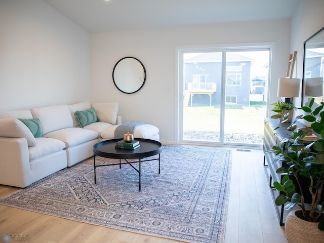 living area with visible vents and wood finished floors
