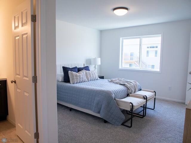 bedroom featuring baseboards and light colored carpet