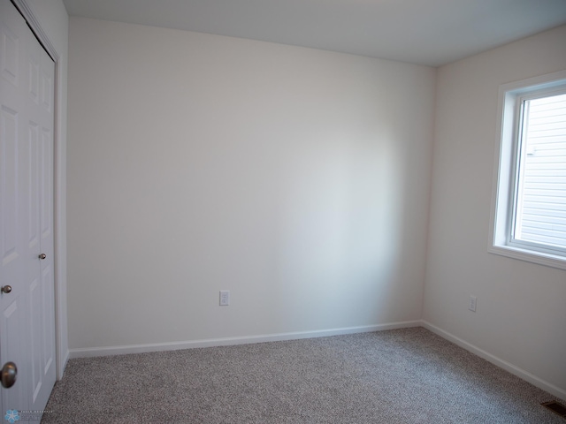 carpeted empty room with baseboards and visible vents