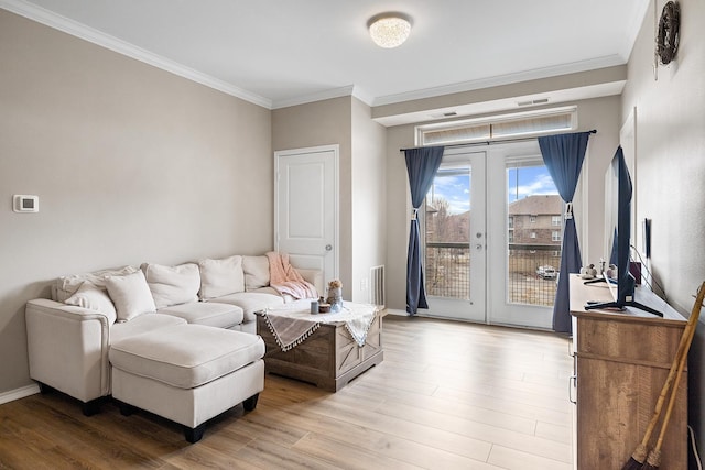 living area with french doors, baseboards, wood finished floors, visible vents, and ornamental molding