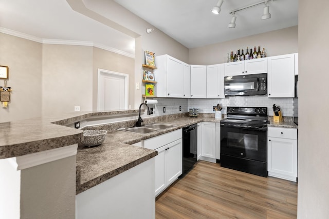 kitchen featuring open shelves, a sink, white cabinets, black appliances, and a peninsula