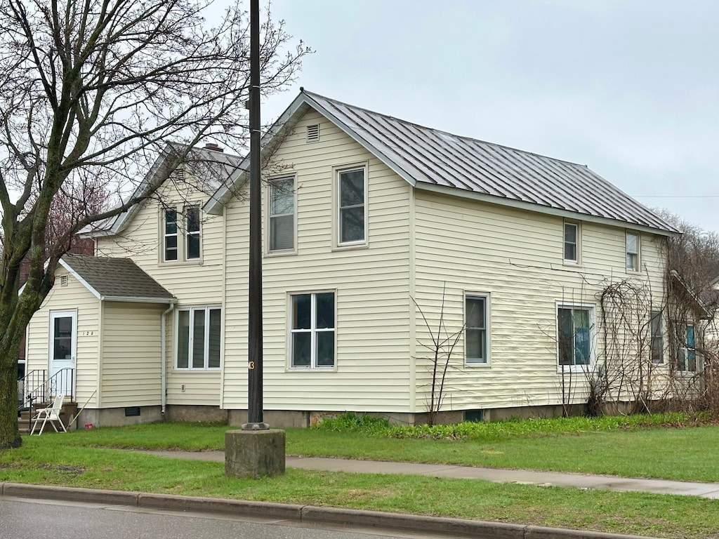 126 Columbia St, Chippewa Falls, WI 54729 - view of property exterior with a lawn and metal roof