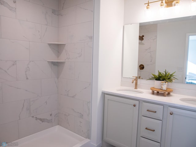 full bathroom featuring a sink, double vanity, and tiled shower