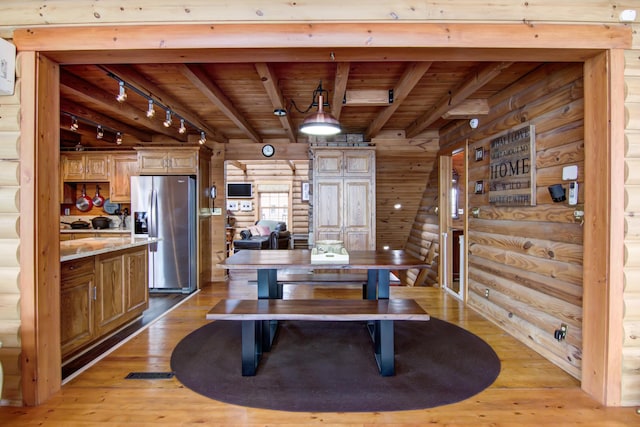 E6516 867th Ave, Colfax, WI 54730 - dining area featuring wood ceiling with exposed beams, light wood finished floors, rustic walls, and track lighting