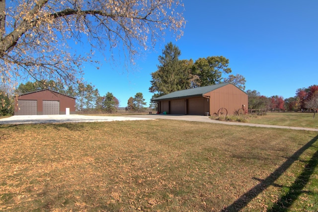 E6516 867th Ave, Colfax, WI 54730 - view of green lawn featuring a detached garage, an outbuilding, and concrete driveway