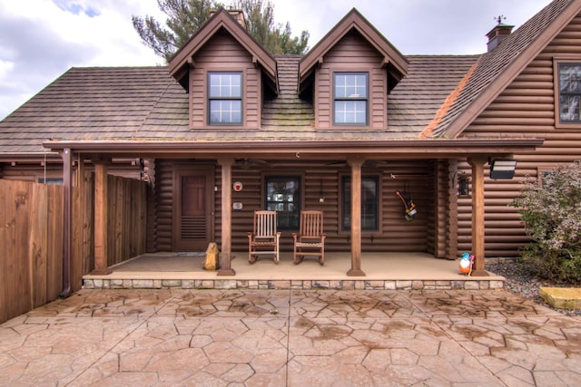 E6516 867th Ave, Colfax, WI 54730 - view of front of home featuring a porch, a chimney, and log siding