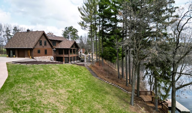 E6516 867th Ave, Colfax, WI 54730 - view of property exterior with a chimney, a garage, stone siding, driveway, and a lawn