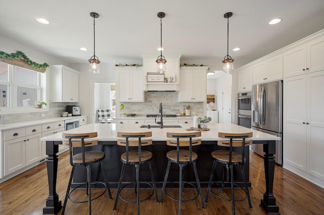 12816 Cedar Ridge Ln, Champlin, MN 55316 - kitchen featuring stainless steel appliances, tasteful backsplash, light countertops, white cabinetry, and an island with sink