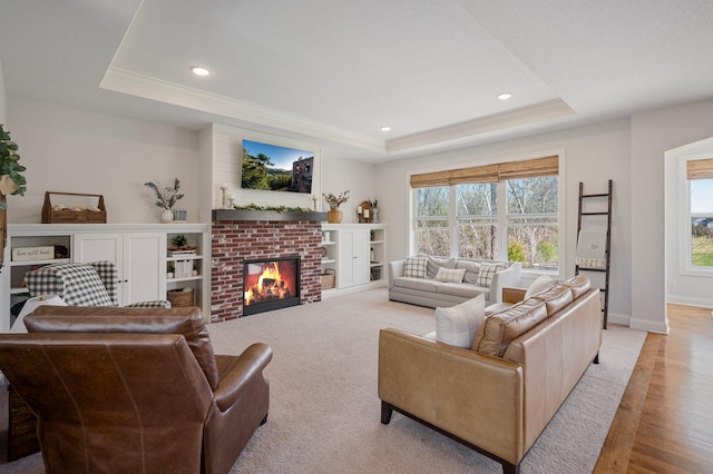 12816 Cedar Ridge Ln, Champlin, MN 55316 - living room featuring a raised ceiling, healthy amount of natural light, light wood-style flooring, ornamental molding, and a fireplace