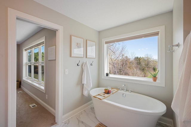 12816 Cedar Ridge Ln, Champlin, MN 55316 - bathroom featuring a freestanding tub and marble look tile flooring