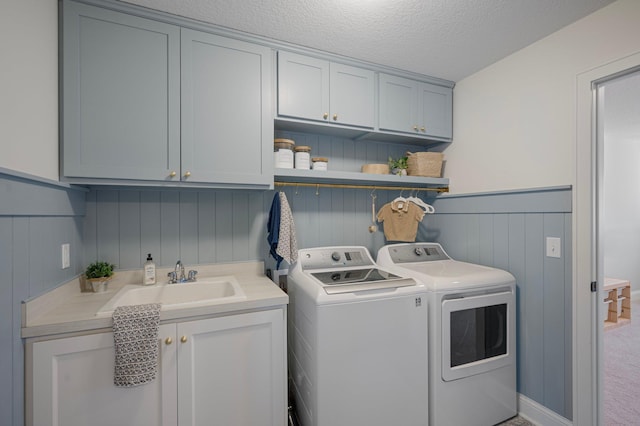 12816 Cedar Ridge Ln, Champlin, MN 55316 - laundry area featuring washer and dryer, cabinet space, a wainscoted wall, and a textured ceiling