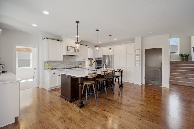 12816 Cedar Ridge Ln, Champlin, MN 55316 - kitchen featuring appliances with stainless steel finishes, recessed lighting, a kitchen breakfast bar, tasteful backsplash, and white cabinets