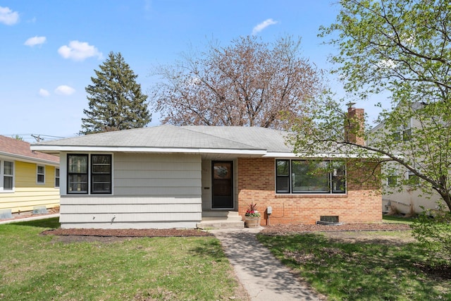 ranch-style home with brick siding, a shingled roof, a front lawn, and a chimney