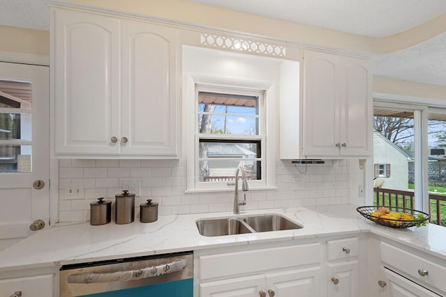 kitchen featuring white cabinetry, tasteful backsplash, a sink, and dishwasher
