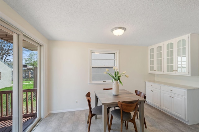 dining area featuring baseboards and a textured ceiling