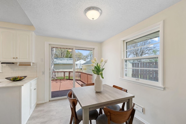 dining space featuring baseboards and a textured ceiling