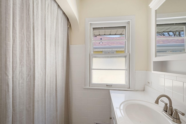 bathroom featuring a shower with curtain, tile walls, and vanity