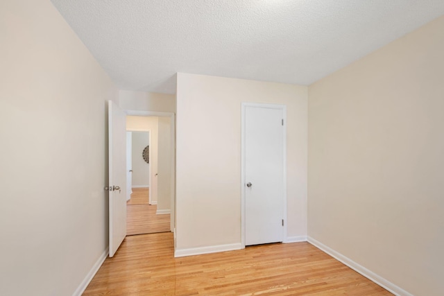 empty room with baseboards and light wood finished floors