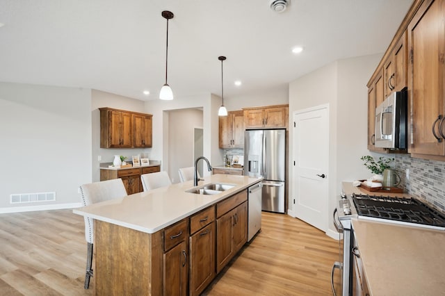 19999 Hunters Rdg, Corcoran, MN 55374 - kitchen with appliances with stainless steel finishes, a sink, backsplash, an island with sink, and recessed lighting