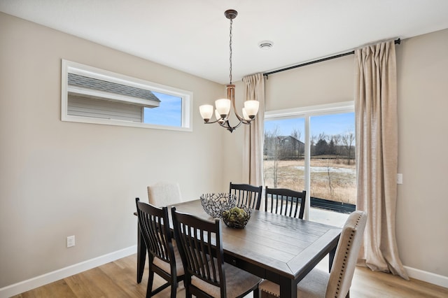 19999 Hunters Rdg, Corcoran, MN 55374 - dining room with a chandelier, baseboards, and light wood finished floors