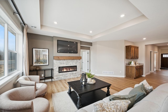 19999 Hunters Rdg, Corcoran, MN 55374 - living room featuring a raised ceiling, light wood-style floors, baseboards, and recessed lighting