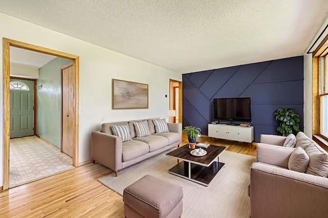 11352 Olive St NW, Coon Rapids, MN 55448 - living area featuring light wood finished floors, an accent wall, baseboards, and a textured ceiling