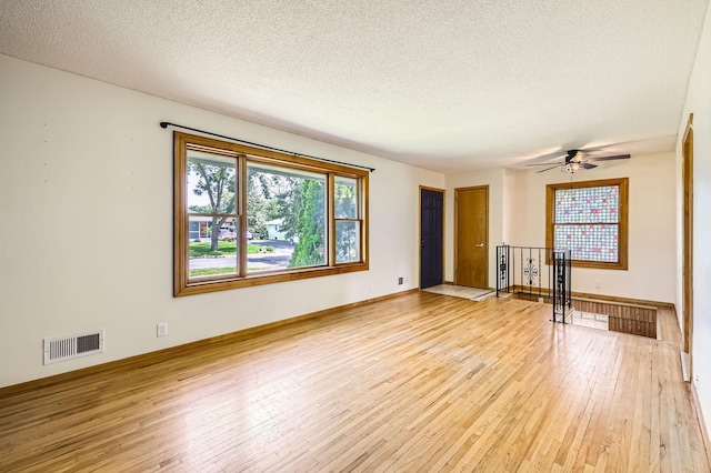 11352 Olive St NW, Coon Rapids, MN 55448 - unfurnished living room with light wood-style flooring, a textured ceiling, a ceiling fan, and baseboards
