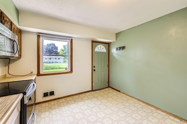 11352 Olive St NW, Coon Rapids, MN 55448 - laundry area featuring a textured ceiling, baseboards, and light flooring