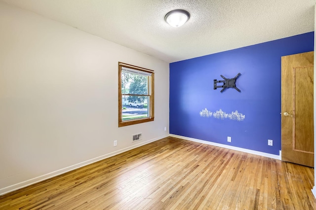 11352 Olive St NW, Coon Rapids, MN 55448 - spare room with wood finished floors, baseboards, and a textured ceiling