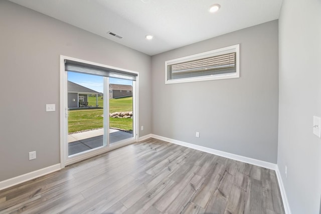 unfurnished room featuring wood finished floors, baseboards, and recessed lighting
