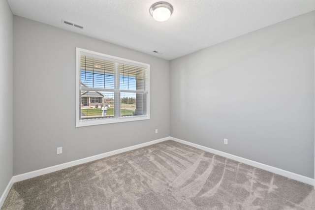 carpeted spare room featuring baseboards