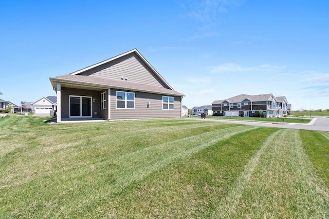 back of property with a yard and a residential view