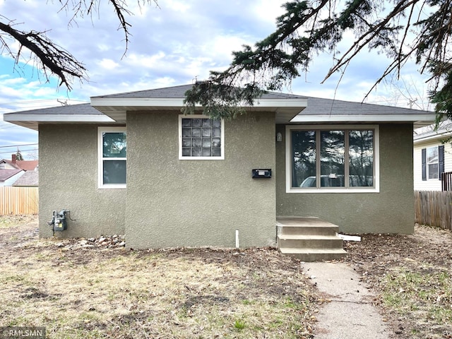 view of front of property with fence and stucco siding