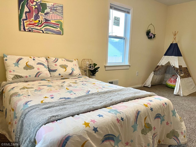 carpeted bedroom featuring baseboards and visible vents