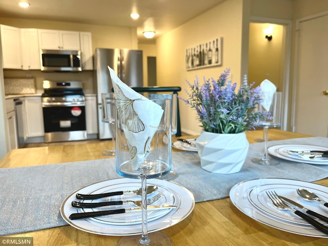 dining space with light wood-style flooring and recessed lighting