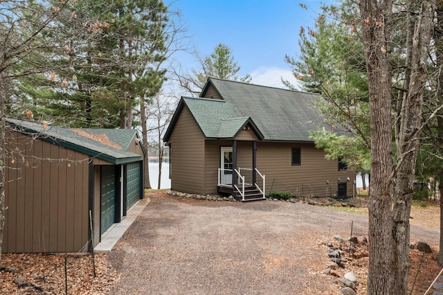 back of property featuring a garage and a shingled roof