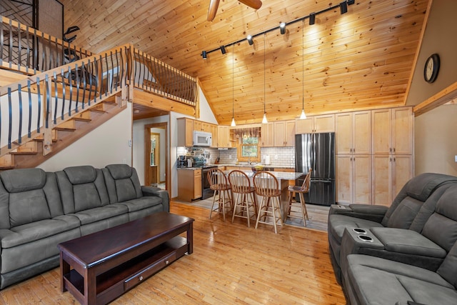 living area featuring wood ceiling, light wood-style flooring, high vaulted ceiling, track lighting, and ceiling fan
