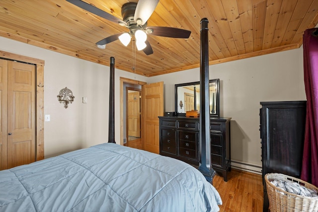 bedroom with a baseboard heating unit, ornamental molding, wood-type flooring, and wood ceiling