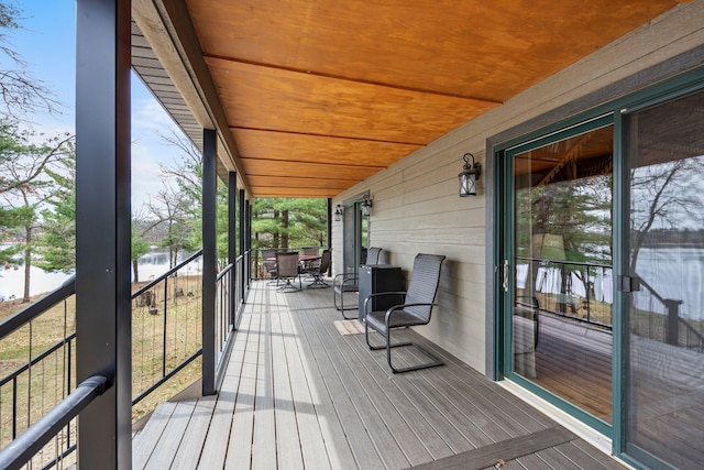 wooden terrace with a porch and a water view