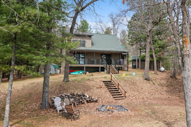 view of front of home featuring stairway, an outdoor structure, and covered porch