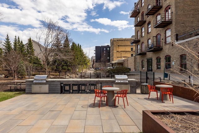 702 1st St Unit 521, Minneapolis, MN 55401 - view of patio featuring a grill, an outdoor kitchen, and fence