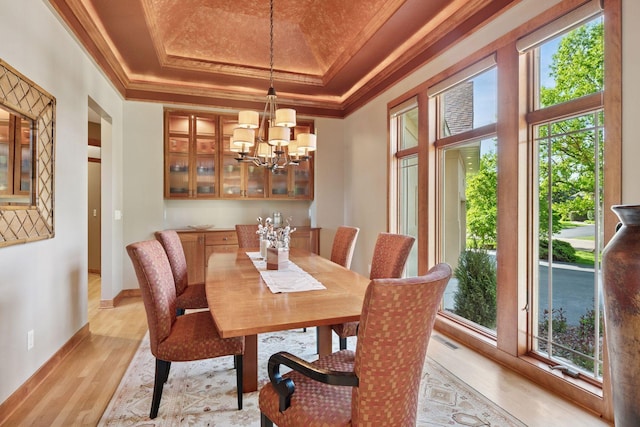 1656 Isabella Pkwy, Chaska, MN 55318 - dining room featuring a tray ceiling, light wood finished floors, ornamental molding, a chandelier, and baseboards