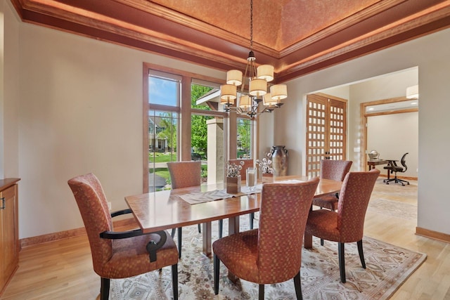1656 Isabella Pkwy, Chaska, MN 55318 - dining area featuring a chandelier, light wood-type flooring, baseboards, ornamental molding, and a raised ceiling