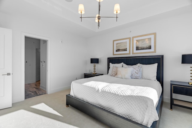 bedroom with an inviting chandelier, baseboards, and carpet floors