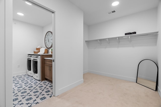 spacious closet with visible vents, independent washer and dryer, and light carpet