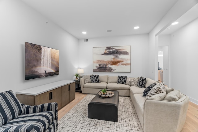 living area with recessed lighting, visible vents, and light wood-style floors