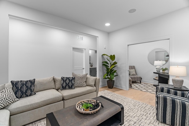 living area with recessed lighting, baseboards, visible vents, and light wood-style floors