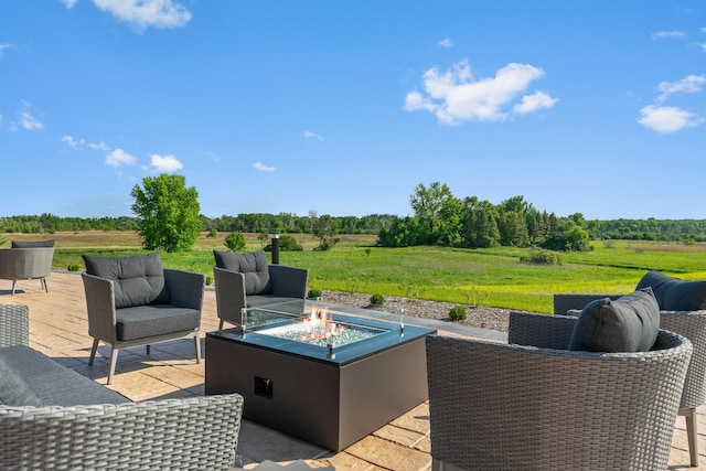 wooden deck featuring an outdoor living space with a fire pit, a patio area, and a rural view